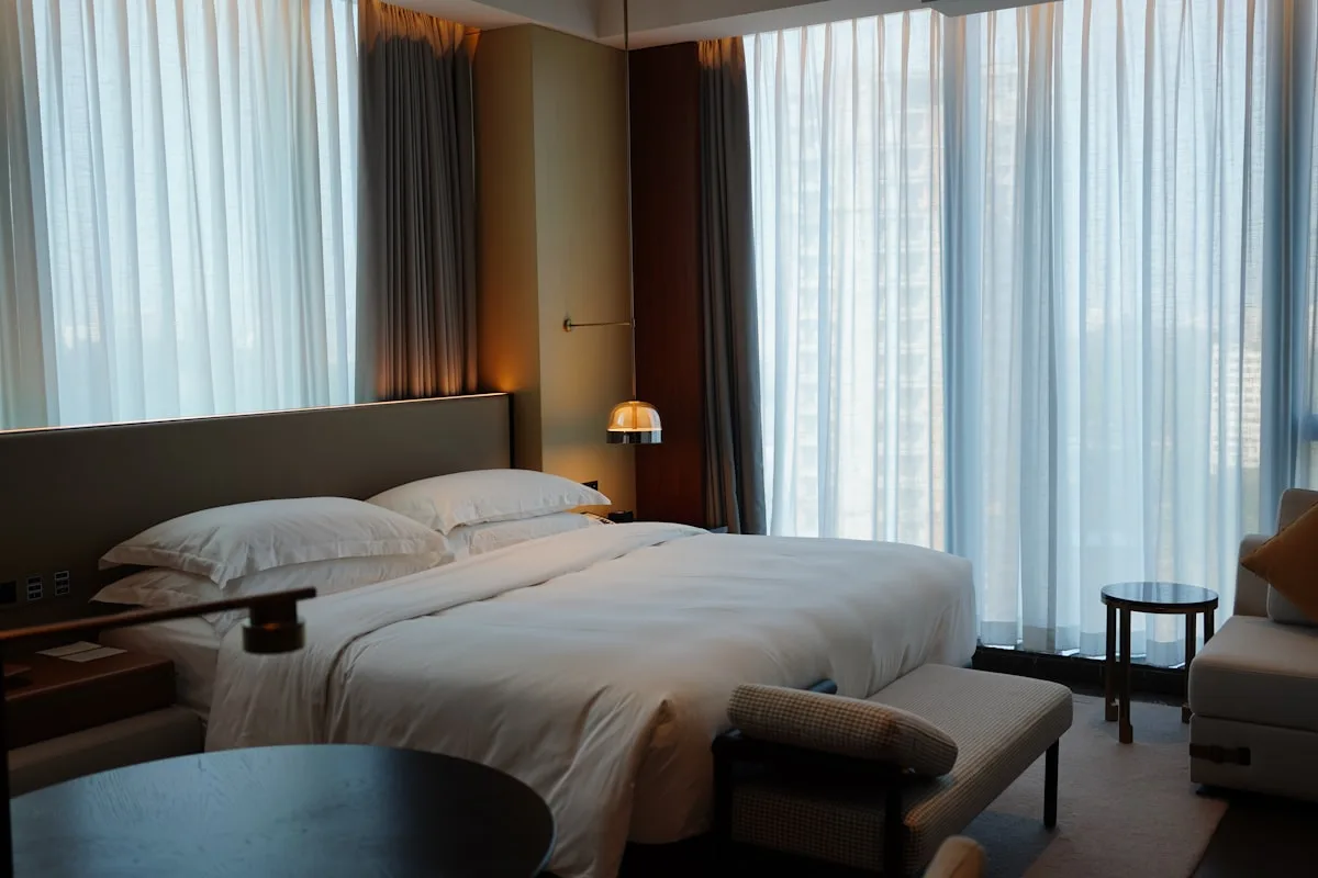 A simple hotel room with a bed next to a window in Dongguan, Guangdong, China