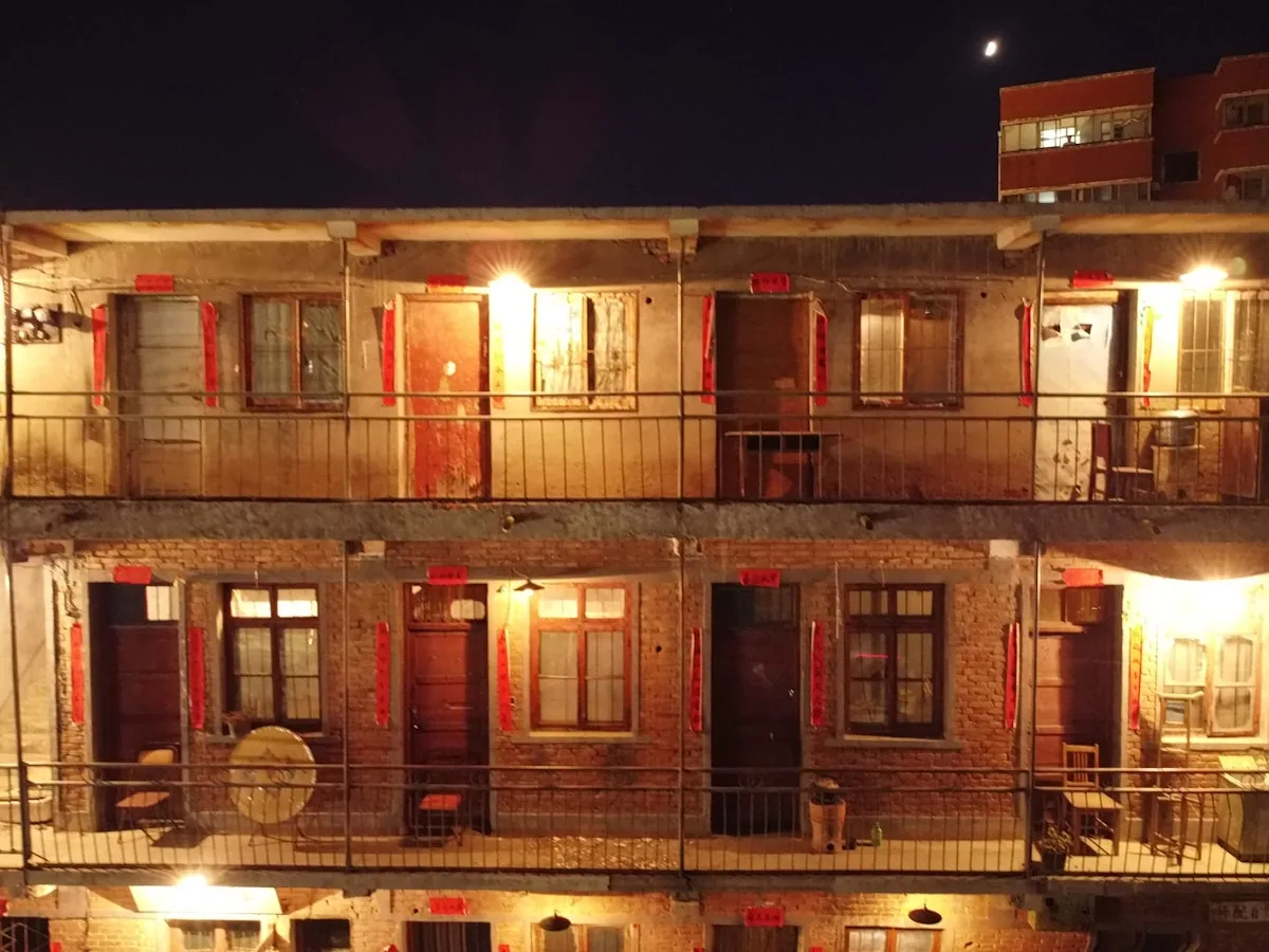 Un edificio residencial antiguo con coplas rojas y luces cálidas