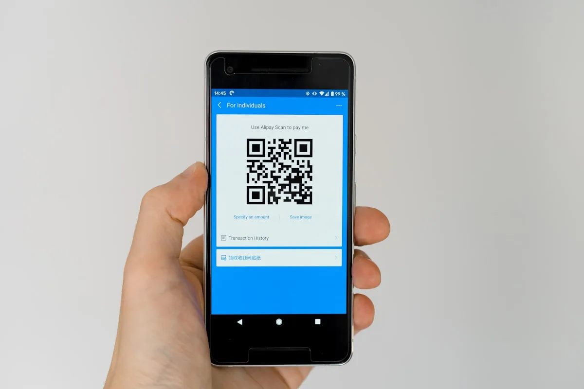 Un teléfono mostrando un código QR de Alipay para recibir pagos