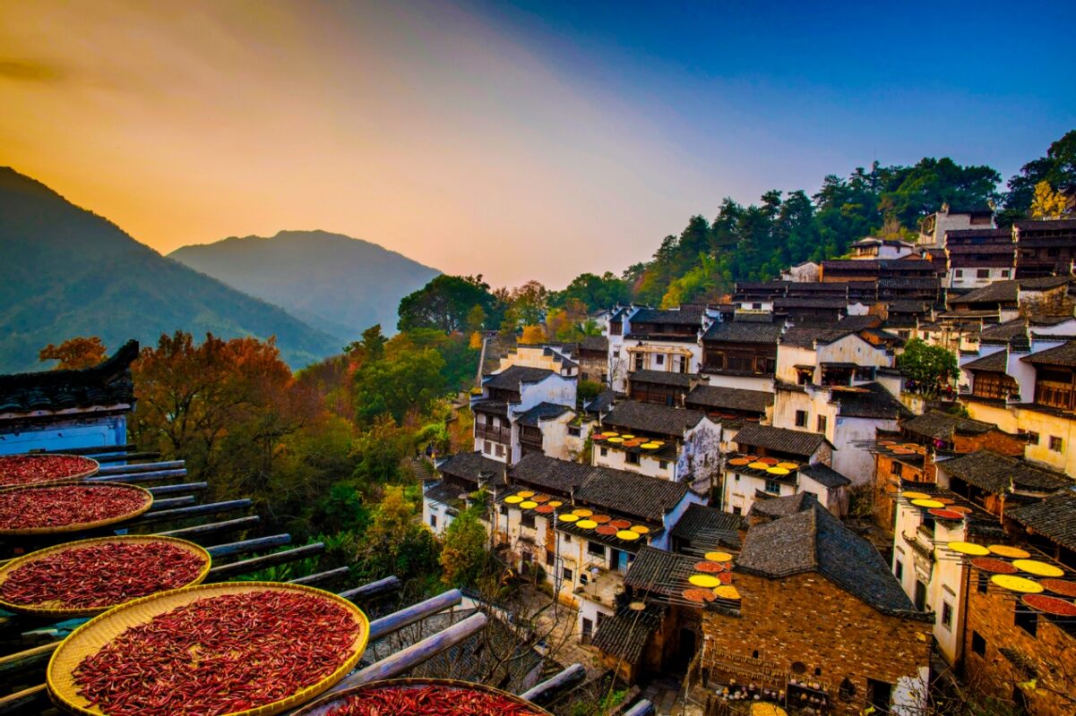 Dense cluster of rural village houses in China with chili peppers drying in the sun