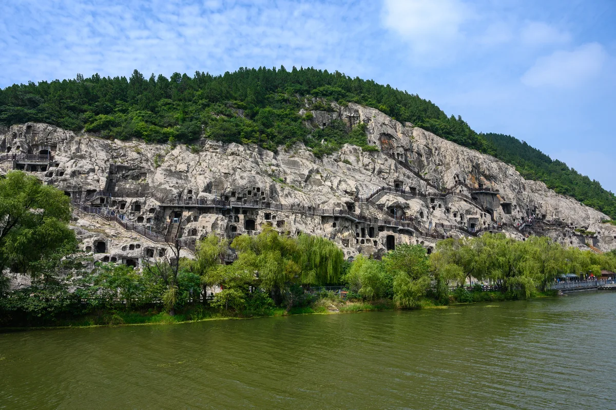 Le dédale de grottes et les passerelles de bois creusées dans la falaise au-dessus de la rivière Yi, aux grottes de Longmen près de Luoyang (Photo: xiquinhosilva via Wikimedia Commons)