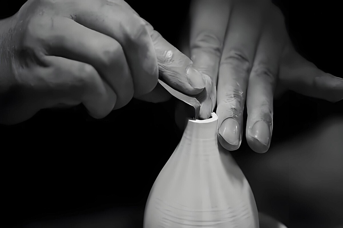 Traditional ceramic pottery workshop in Jingdezhen with artisan hands shaping clay