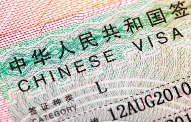Chinese passport and visa stamps on a travel desk