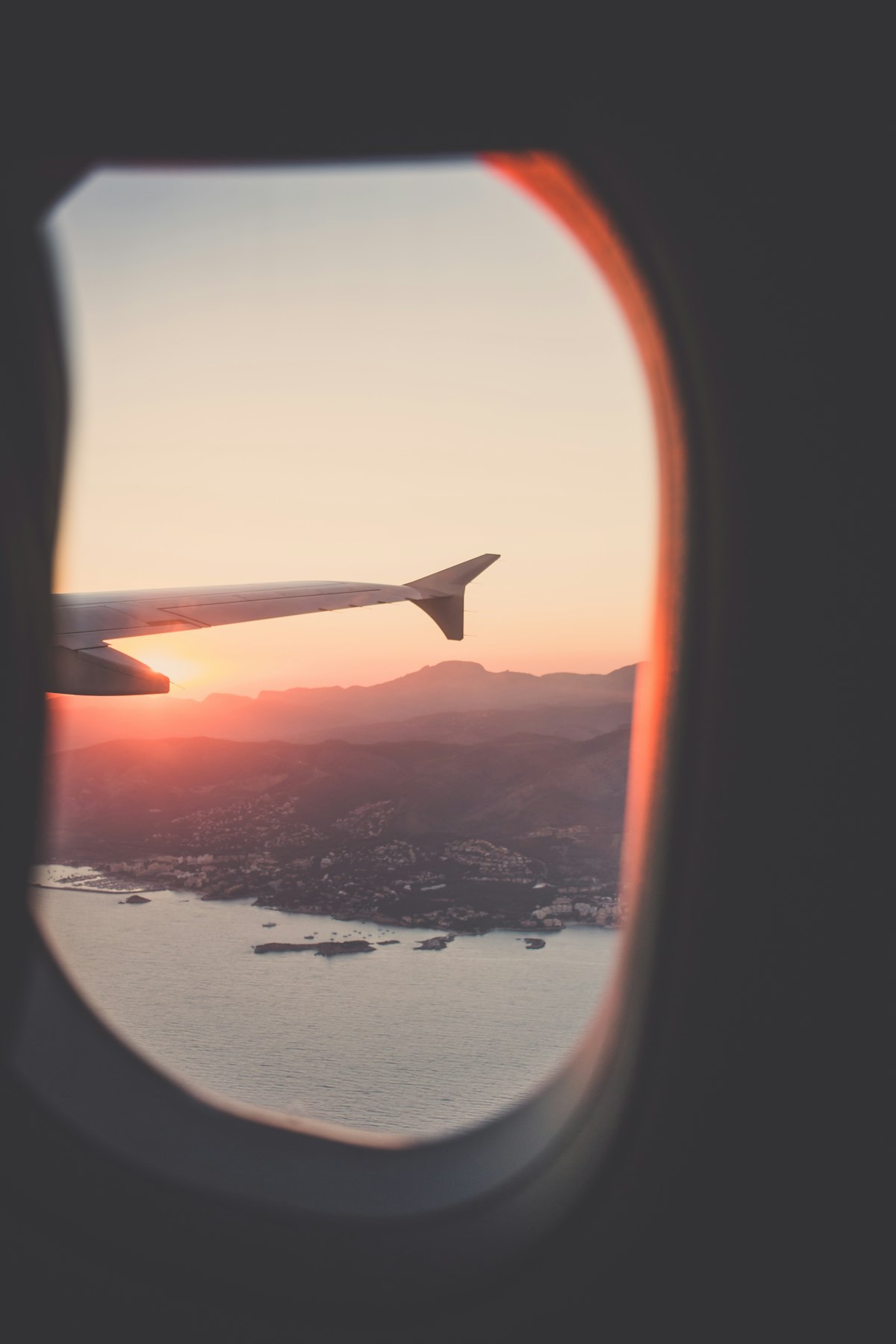 Airplane wing above clouds at sunset — seasonal travel to China