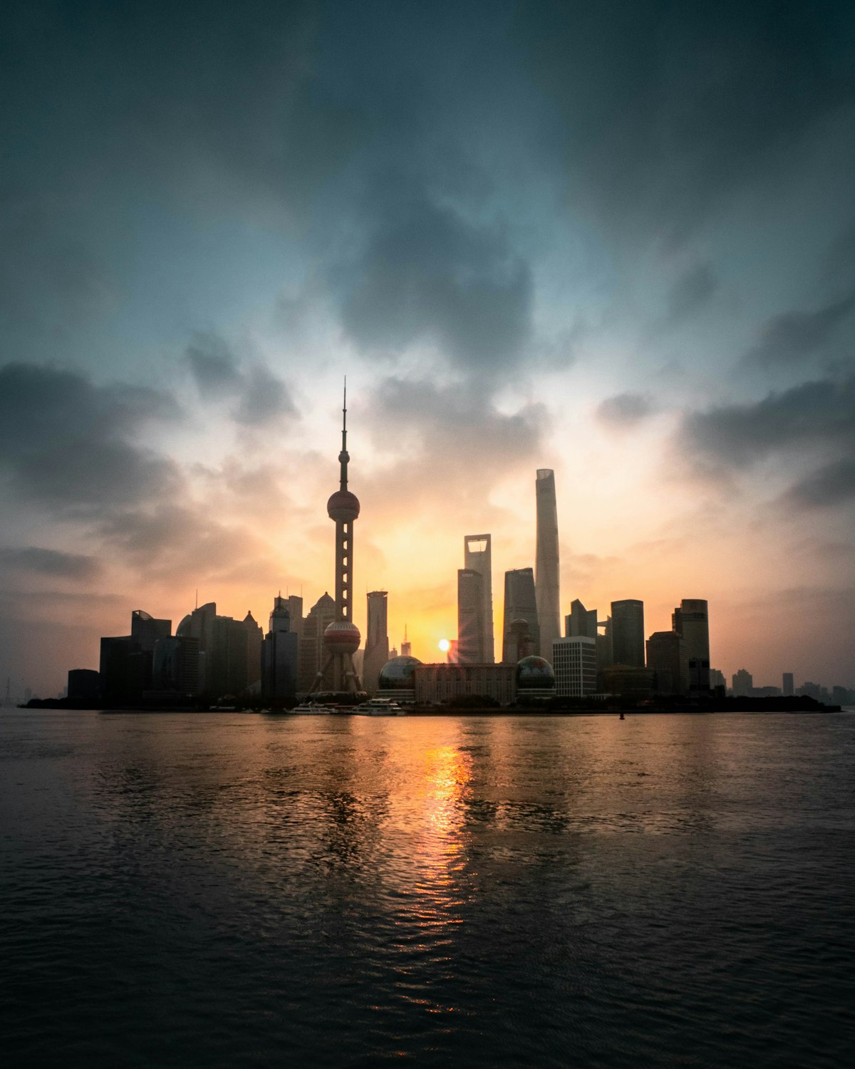 The Bund at sunrise — colonial-era heritage buildings on the left, Pudong's futuristic skyline across the Huangpu River on the right