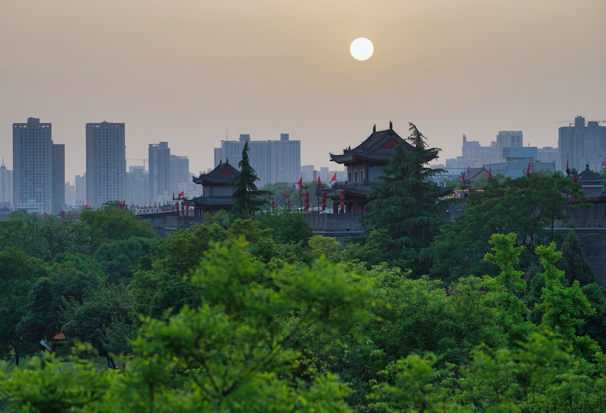 Cycling atop the Xi'an City Wall at sunset — a 13.7 km loop with old city rooftops on one side and the modern skyline on the other