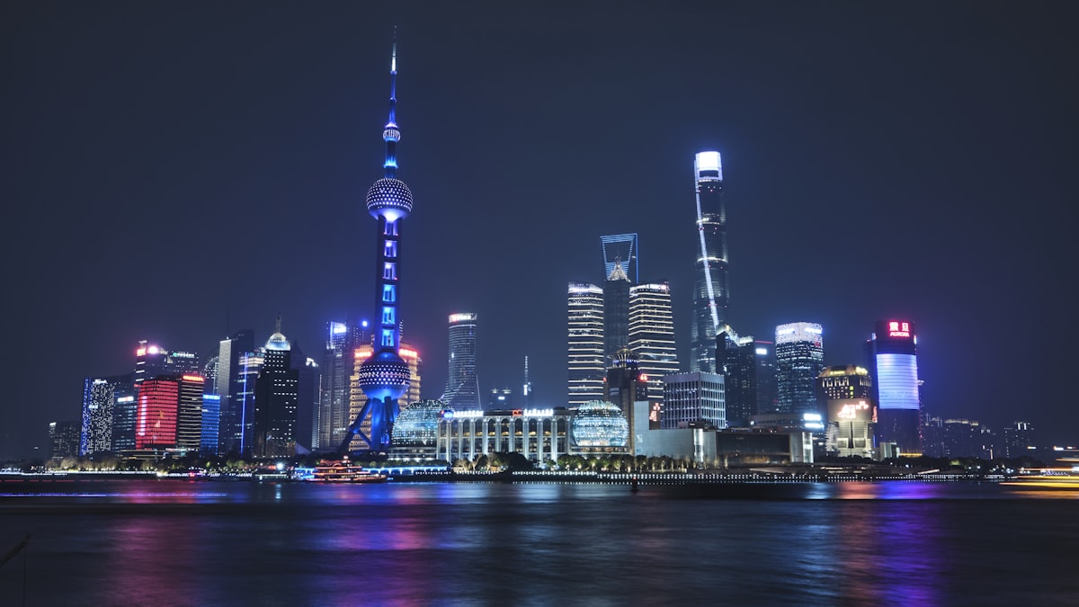 Shanghai skyline at night with lights reflecting on the Huangpu River