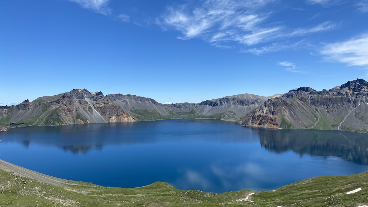 A bright blue alpine lake surrounded by mountains in Xinjiang