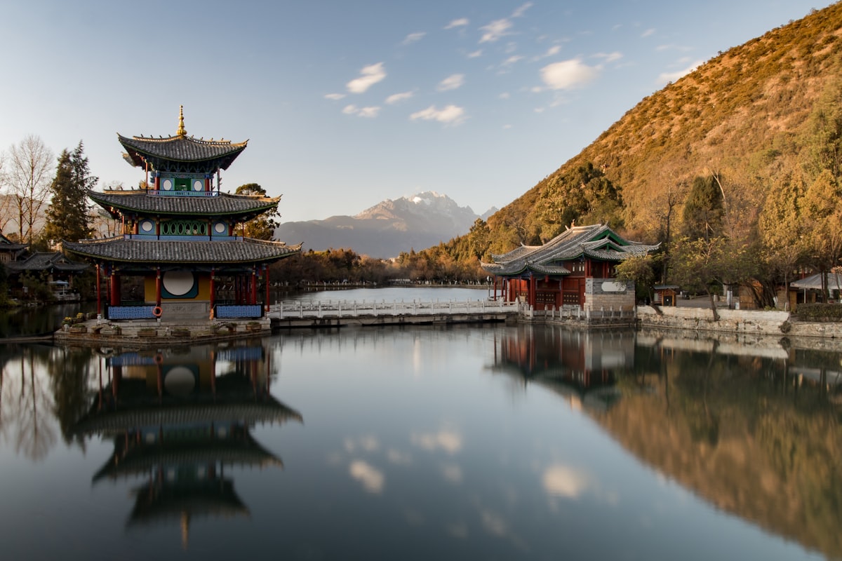Pagoda on a lake with mountains behind in Lijiang, Yunnan — the Golden Route
