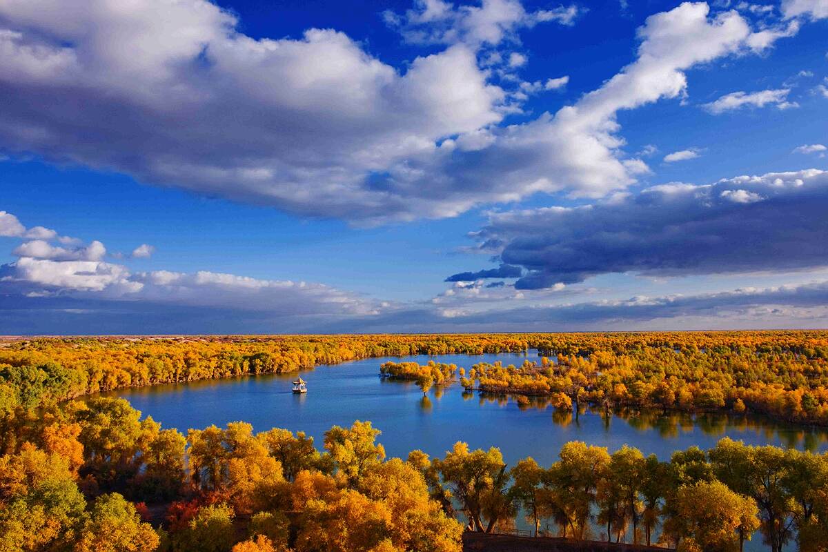 Xinjiang grasslands with snow-capped mountains and yurts on the horizon