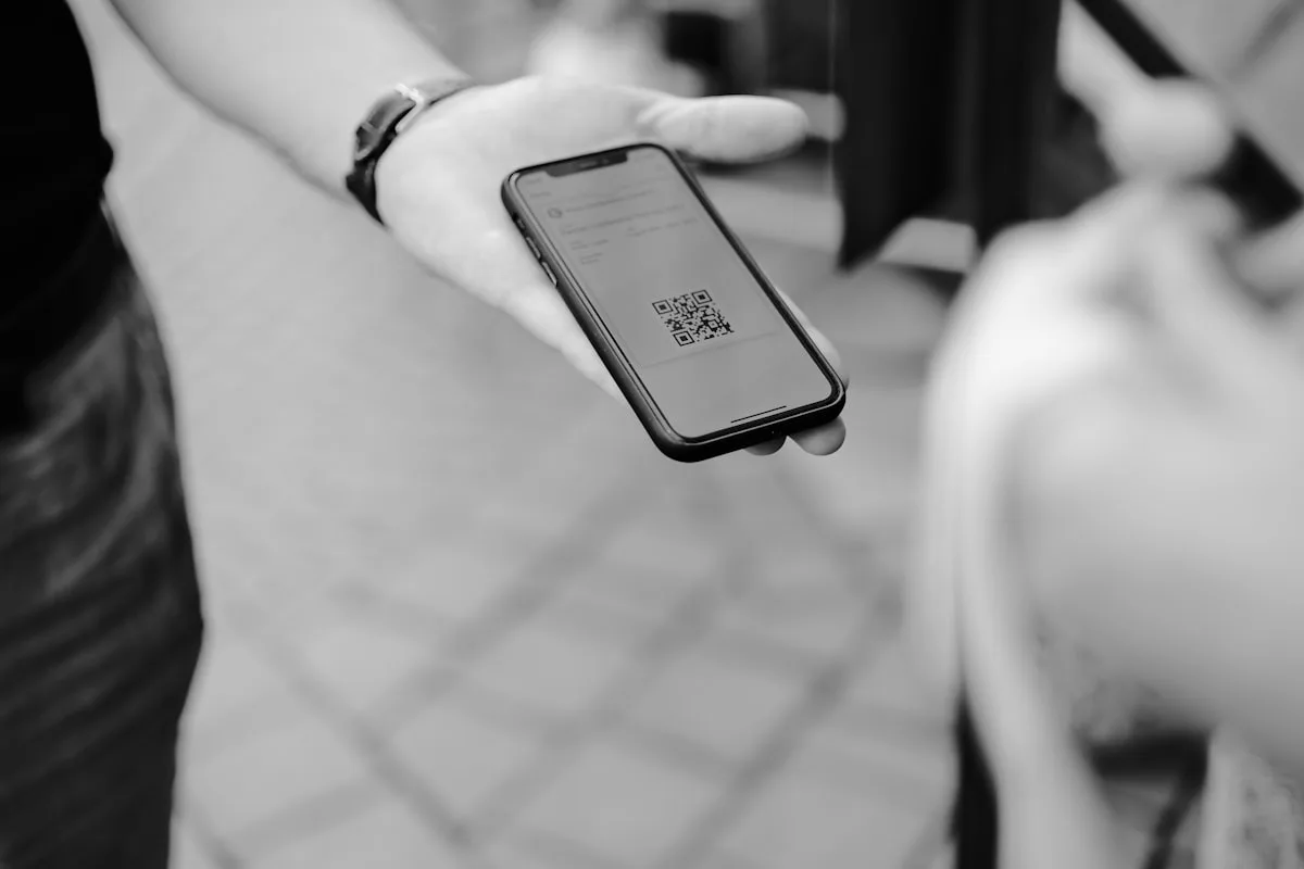 A person holding a phone showing a mobile payment QR code screen