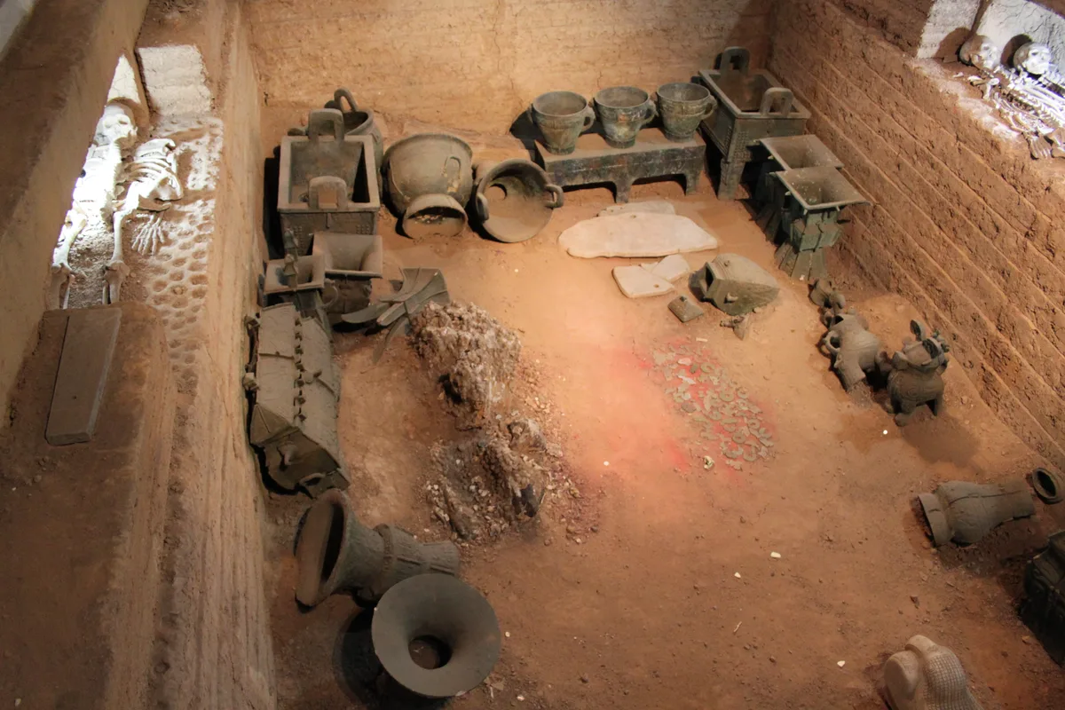 A tumba escavada de Fu Hao em Yin Xu, com vasos de bronze, espelhos e um esqueleto humano dispostos no fundo do fosso como foram encontrados (Photo: Gary Todd via Wikimedia Commons)