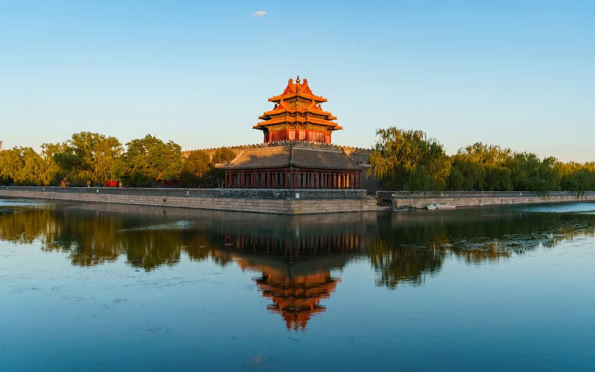 bâtiment brun en béton près d'arbres verts et d'un lac en journée
