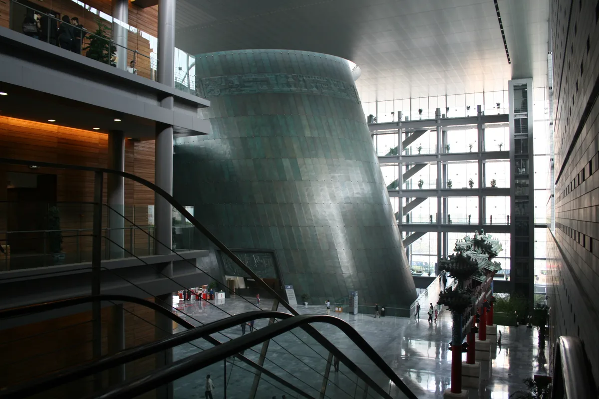 L'atrium cylindrique couleur bronze à l'intérieur du Musée de la capitale à Pékin, avec ses escalators et des visiteurs en contrebas (Photo: Gary Lee Todd, Ph.D. via Wikimedia Commons)