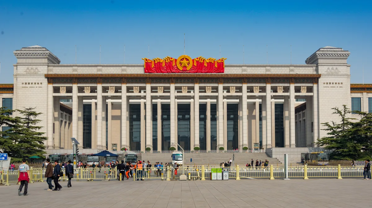 La façade à colonnes du Musée national de Chine, côté est de la place Tiananmen, avec des visiteurs en file derrière des barrières (Photo: xiquinhosilva via Wikimedia Commons)