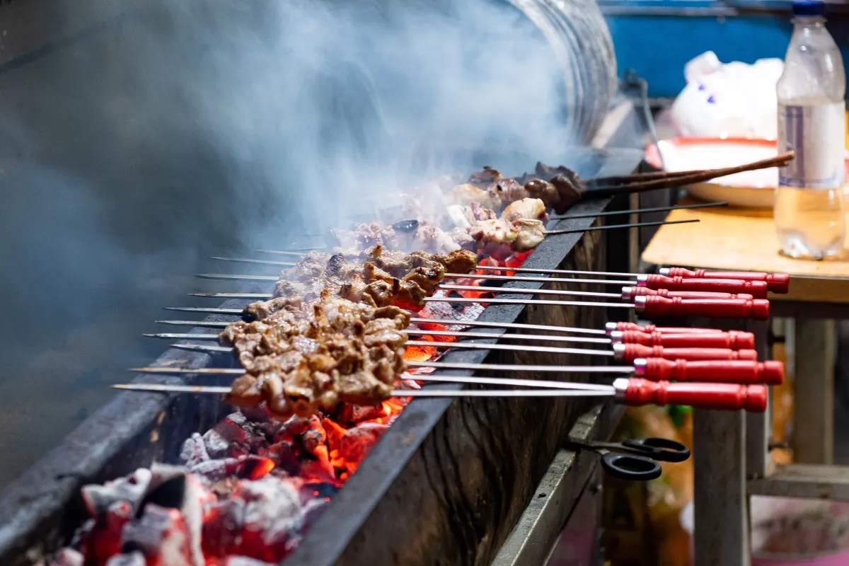Brochetas de cordero asándose en un puesto callejero de Kashgar (Foto: N509FZ via Wikimedia Commons)