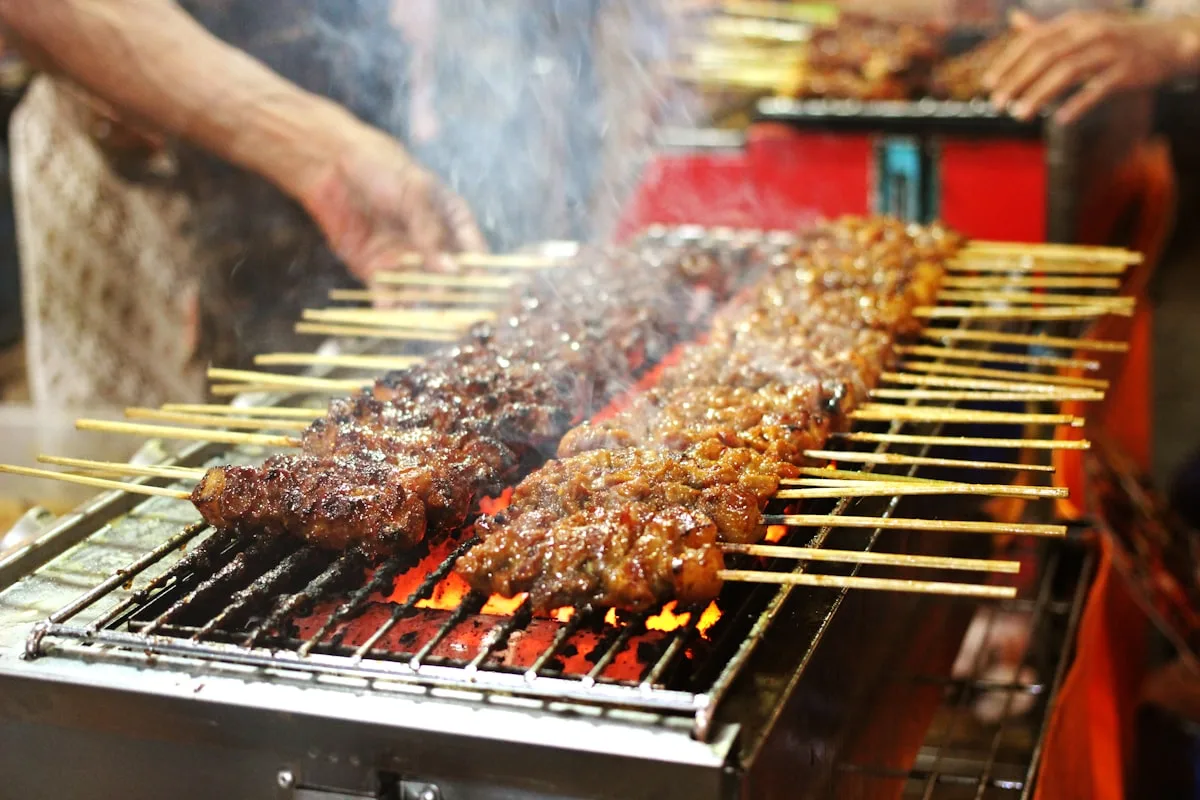 Grilled meat skewers over charcoal at a Chinese street food stall