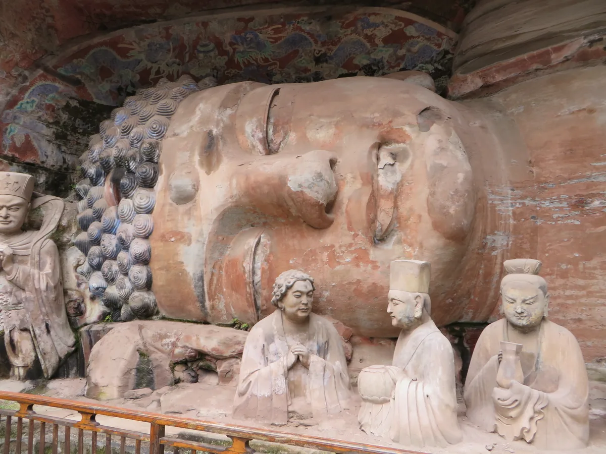 The 31-meter Reclining Buddha carved into the Baodingshan cliff at Dazu, his disciples carved at half-scale around him (Photo: Jpbowen via Wikimedia Commons)