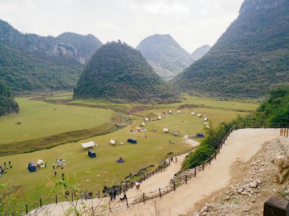 Karst mountains rising from the landscape in Guizhou province near Guiyang, tents set up in the valley below