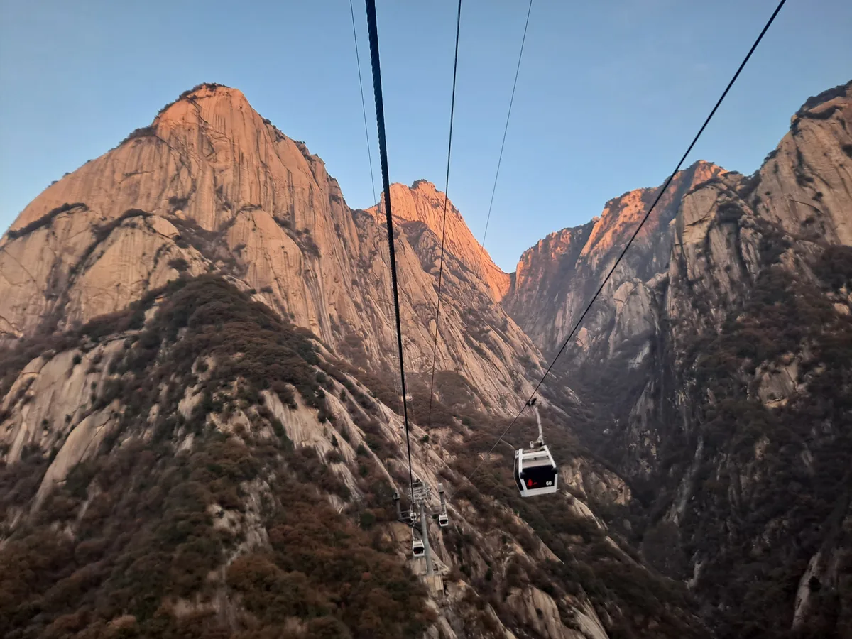 Une cabine du téléphérique ouest au-dessus d'une gorge de granit à Huashan, avec la lumière de l'après-midi sur les parois (Photo: H2v5o68z via Wikimedia Commons)