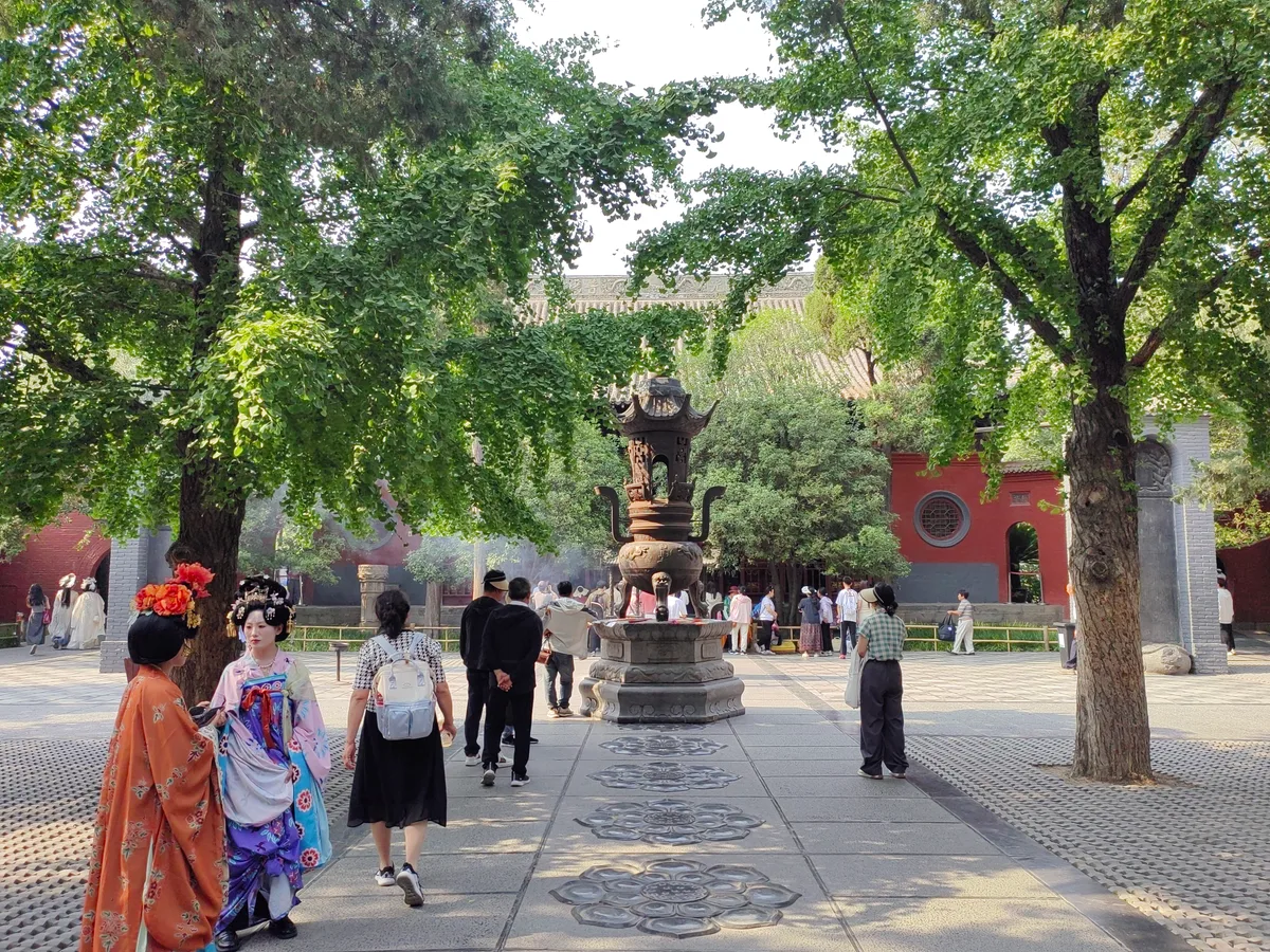 Deux visiteuses en hanfu Tang richement apprêtées, avec coiffes fleuries, traversant la cour du pavillon du Grand Bouddha au temple du Cheval blanc à Luoyang (Photo: Yumeto via Wikimedia Commons)