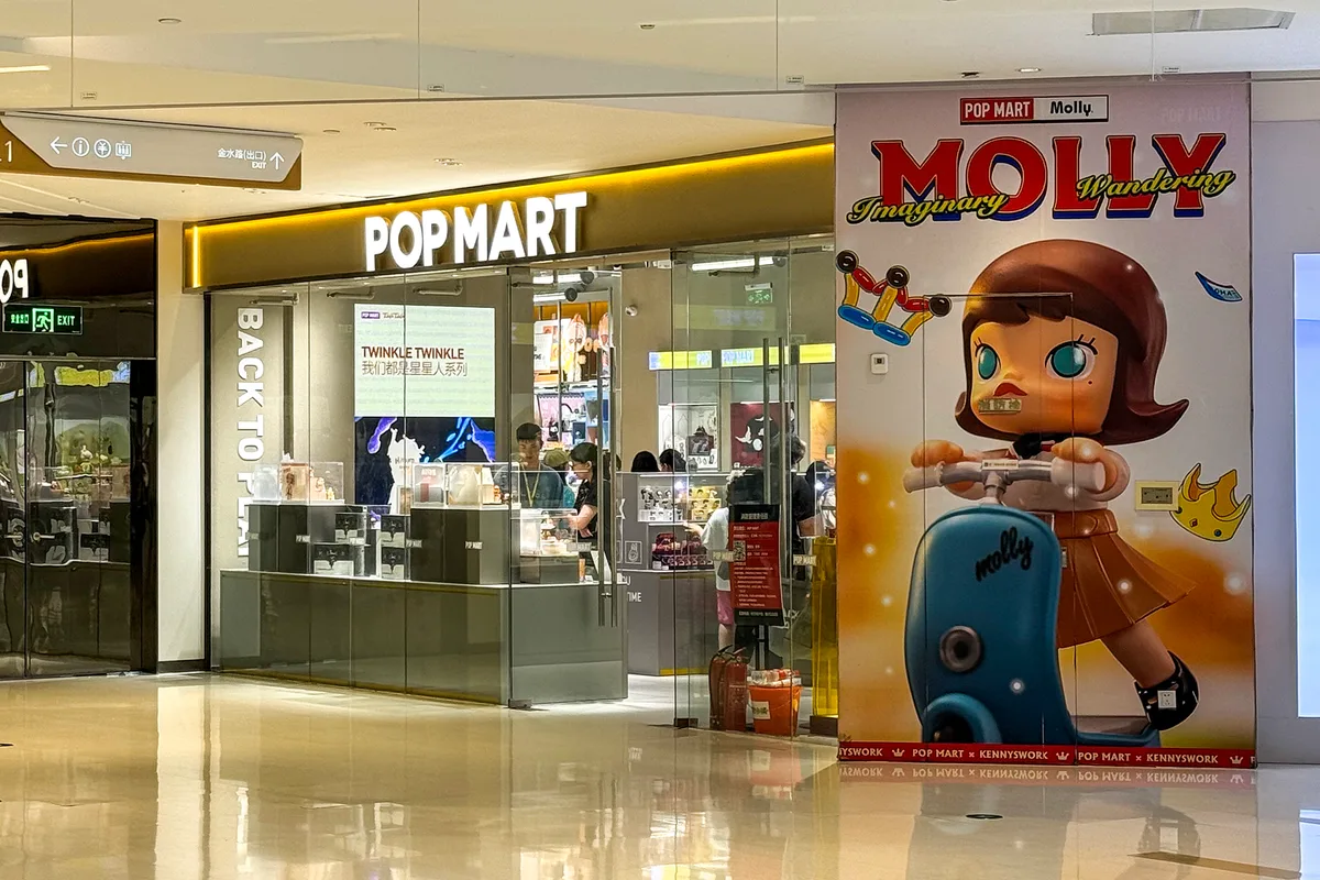 Une boutique Pop Mart dans un centre commercial chinois, avec une grande affiche Molly à côté de la vitrine et des clients à l'intérieur (Photo: Windmemories via Wikimedia Commons)