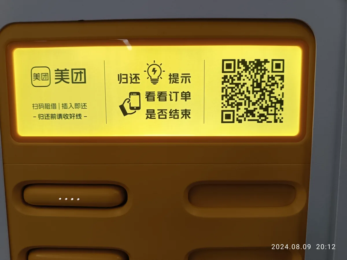 Uma estação amarela de devolução de power banks compartilhados da Meituan, com QR code e instruções em chinês, no saguão de uma estação de metrô em Shenzhen (Foto: ChaoYi22 via Wikimedia Commons)