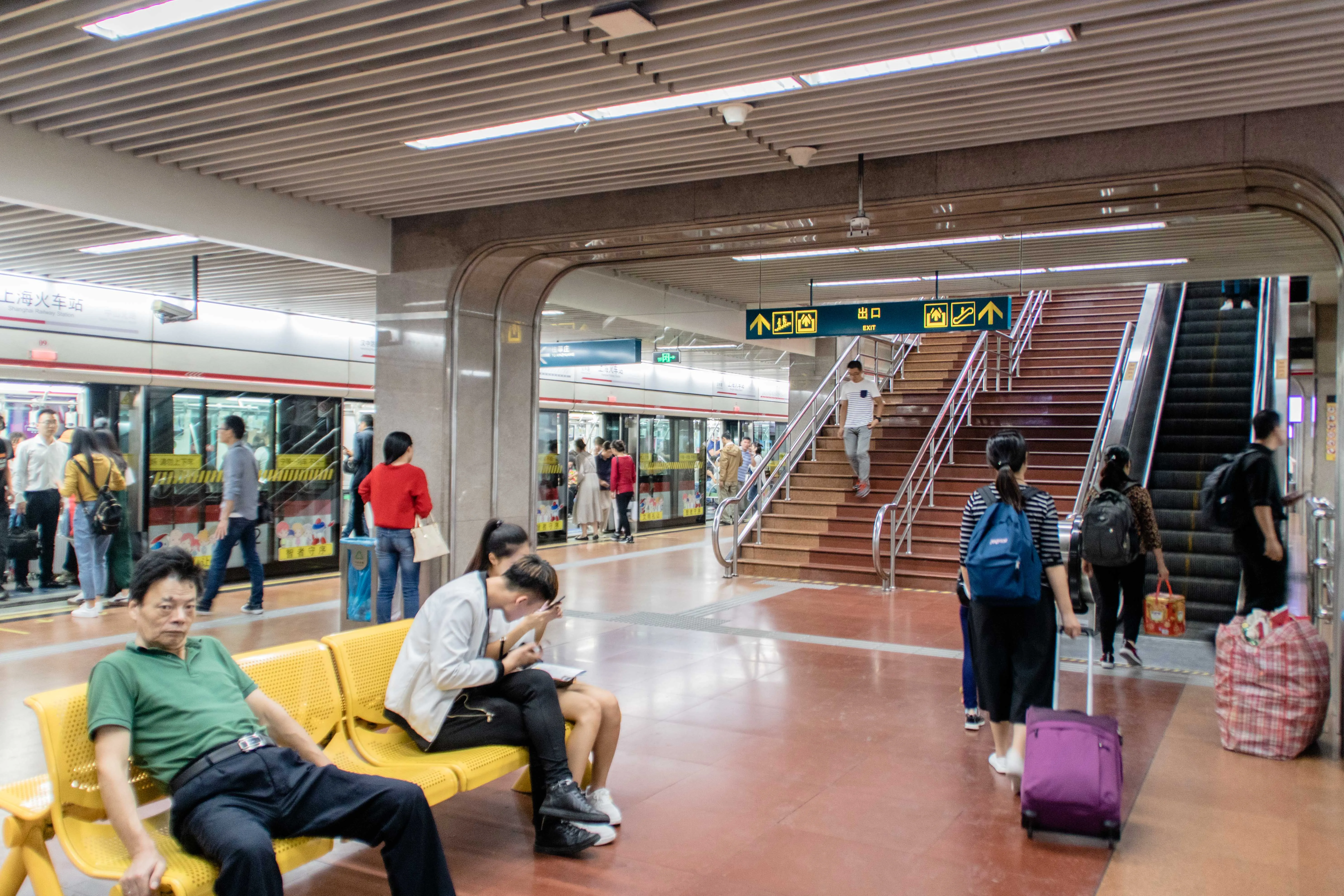 The platform at Shanghai Railway Station metro stop with a train waiting behind the yellow safety line and passengers lining up to board (Photo: SCJiang via Wikimedia Commons)