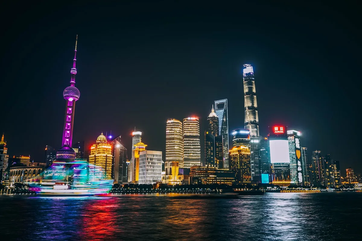 The illuminated Pudong skyline across the Huangpu River at night, viewed from Shanghai's Bund waterfront