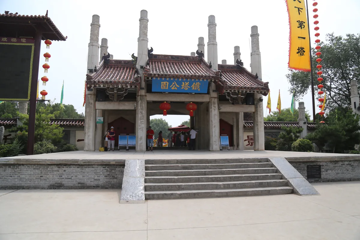 El arco de entrada decorado del parque de la Pagoda de Hierro en Kaifeng, con farolillos rojos y una pancarta que proclama «la mejor pagoda bajo el cielo» (Photo: Jiangshang Qingfeng 1961 via Wikimedia Commons)