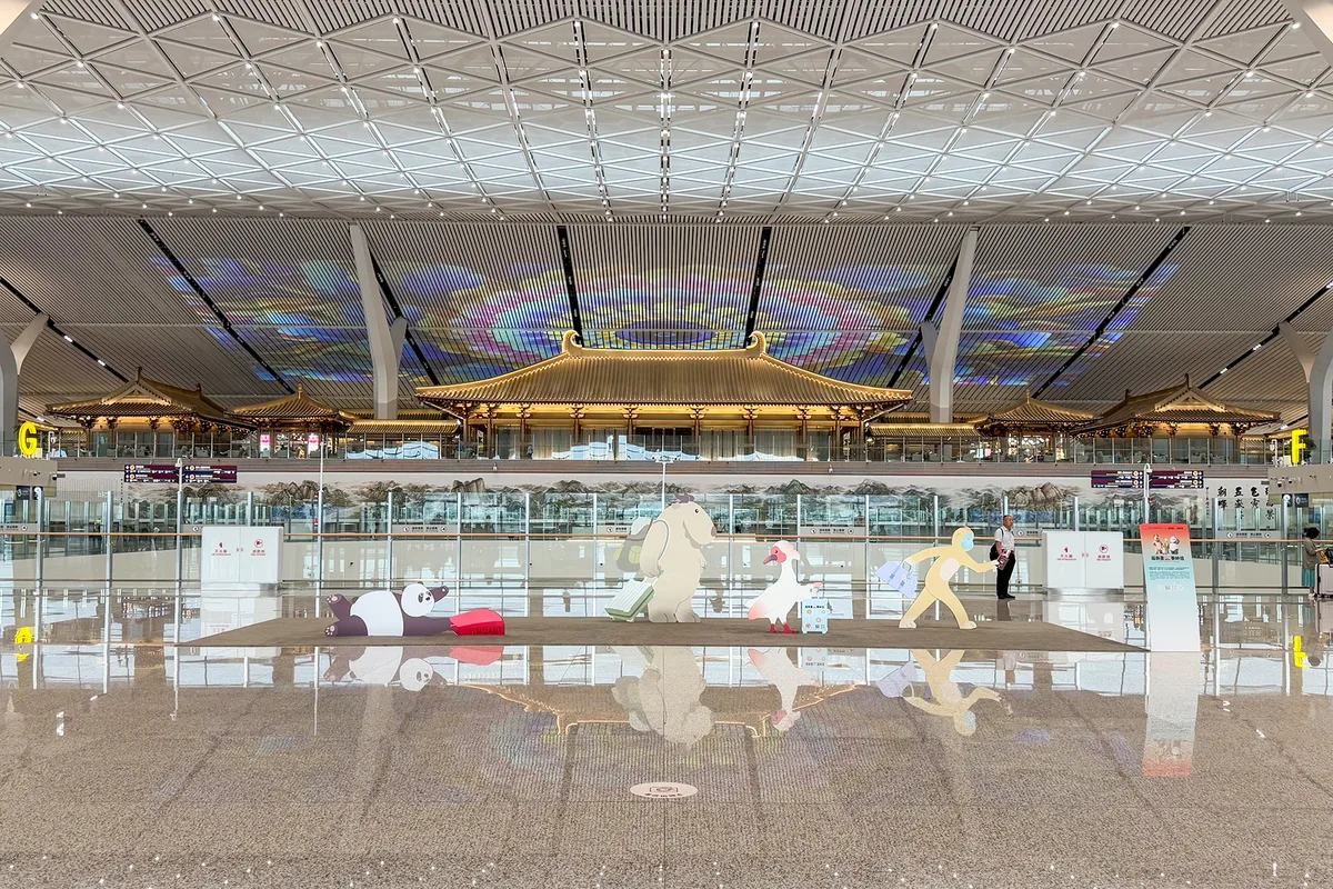 Une vue large du hall d'enregistrement du terminal 5 de l'aéroport international de Xi'an Xianyang, avec son plafond en projection vidéo et des mascottes sur le sol du hall (Photo: Windmemories via Wikimedia Commons)