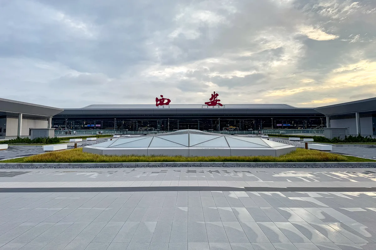 La terminal 5 del aeropuerto internacional de Xi'an Xianyang vista desde la plaza al atardecer, con los caracteres rojos de Xi'an en la línea del tejado (Photo: Windmemories via Wikimedia Commons)