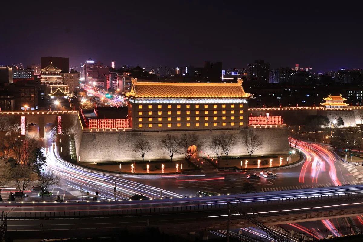 Ancient Chinese city gate illuminated at night with light trails in Xi'an