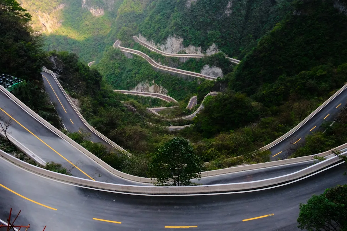 Carretera de montaña sinuosa con curvas cerradas y vegetación exuberante