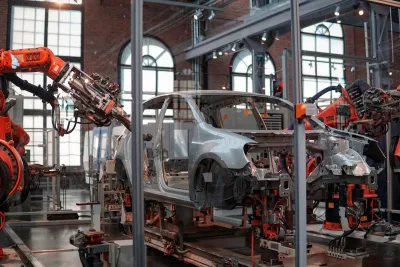 Robotic arms assembling a vehicle inside a modern automated car factory