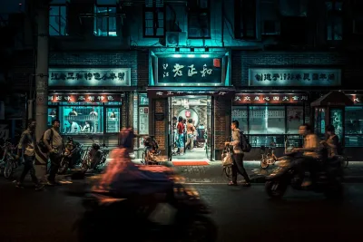 Rue animée la nuit avec des motos et des piétons