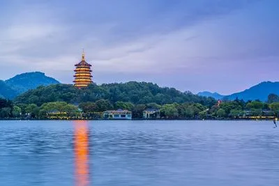 West Lake in Hangzhou with traditional pavilion and lush green hills