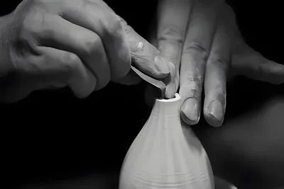 Traditional ceramic pottery workshop in Jingdezhen with artisan hands shaping clay