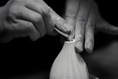 Traditional ceramic pottery workshop in Jingdezhen with artisan hands shaping clay