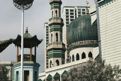 Green and white concrete dome of a mosque in China under blue sky