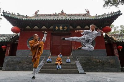 Shaolin Temple monks practicing martial arts in traditional courtyard