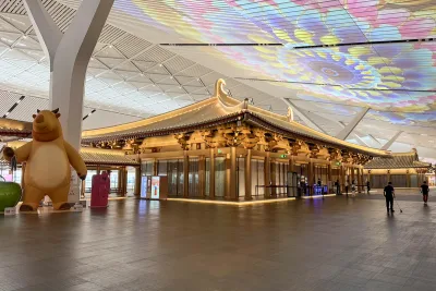The gold-roofed Tang-style pavilion of the West Airport Museum standing in the concourse of Terminal 5 at Xi'an Xianyang International Airport, under a projection-mapped ceiling (Photo: Windmemories via Wikimedia Commons)