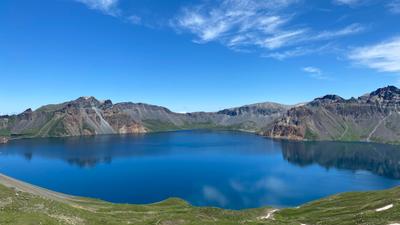 A bright blue alpine lake surrounded by mountains in Xinjiang