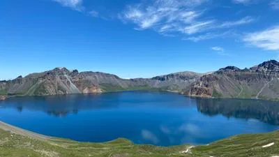 A bright blue alpine lake surrounded by mountains in Xinjiang
