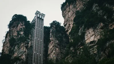 The Bailong Elevator climbing a sheer sandstone cliff inside Zhangjiajie National Forest Park, with forested karst pillars on either side